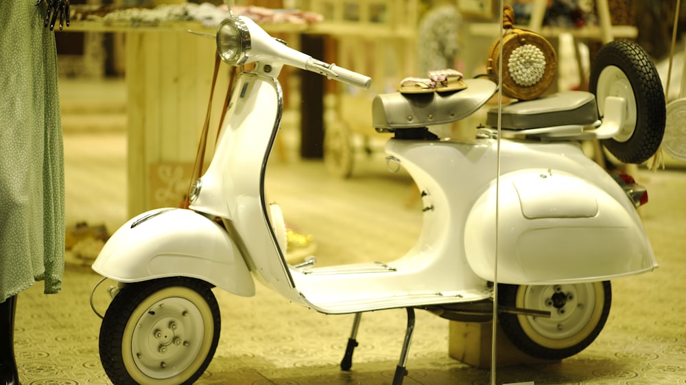 white motor scooter parked on gray concrete pavement during daytime