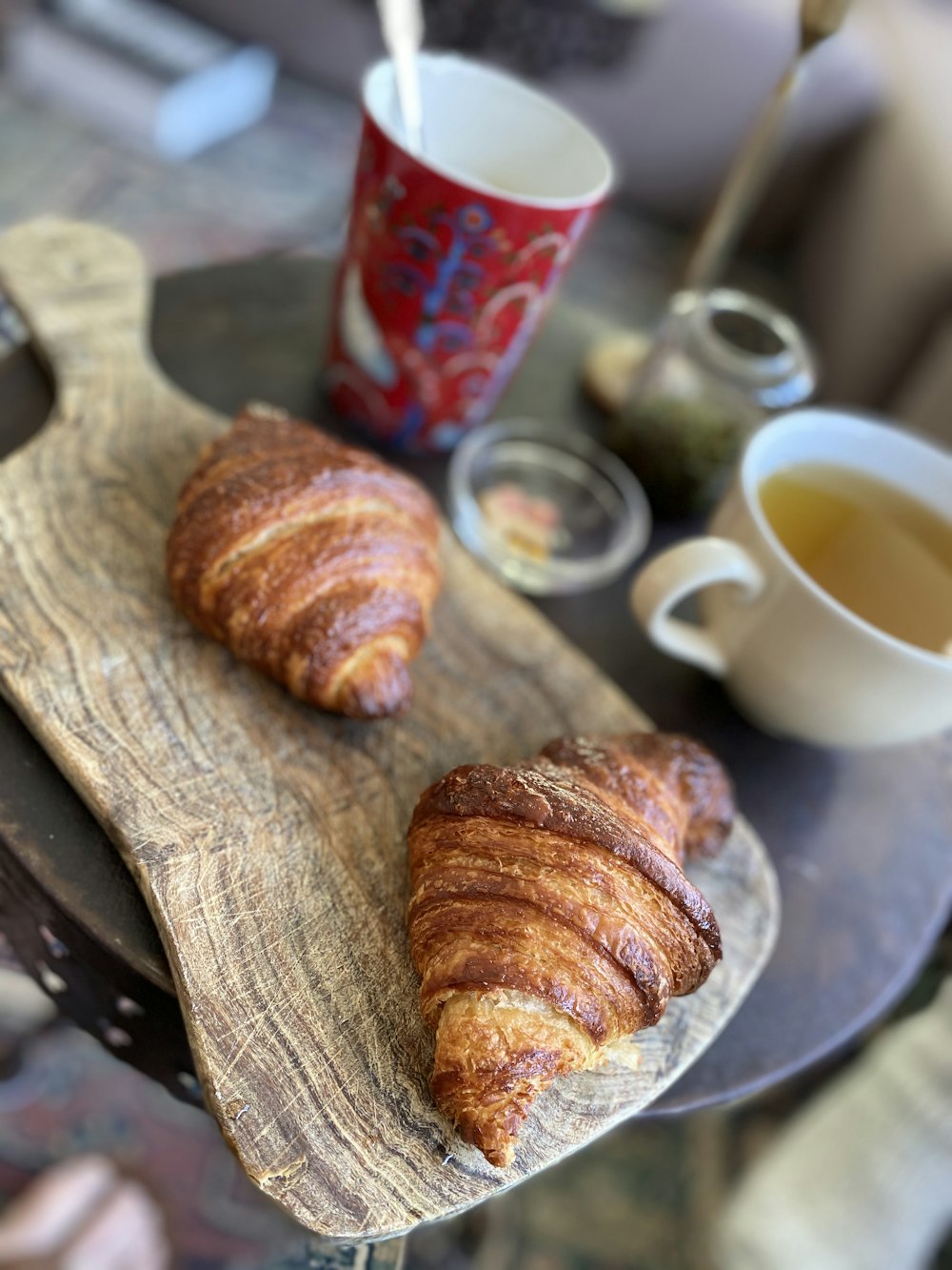 Tasse en céramique blanche à côté du pain brun sur une planche à découper en bois brun