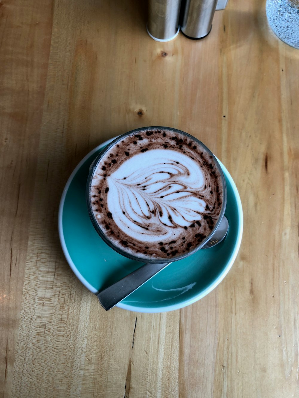 taza de cerámica azul con arte de café en forma de corazón