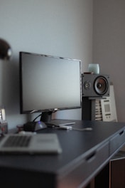 black flat screen computer monitor on black wooden desk