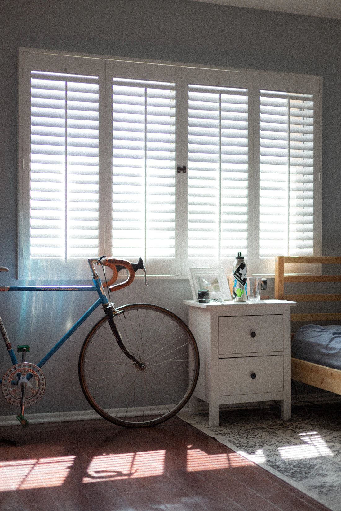 Bright bedroom window fitted with white plantation shutters