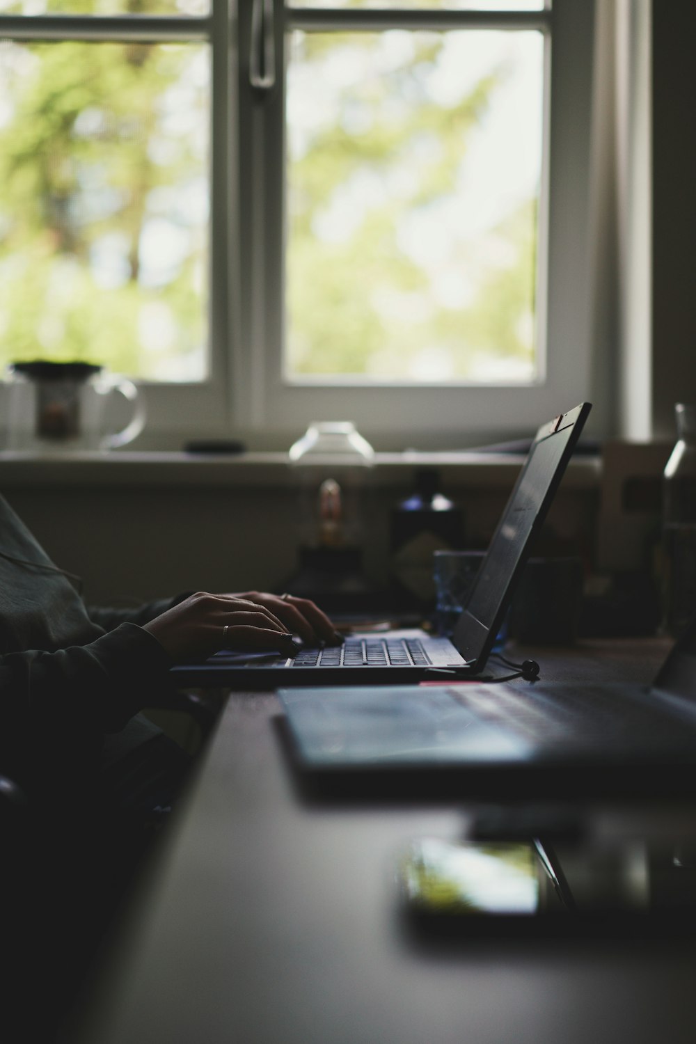 person using laptop computer near window during daytime