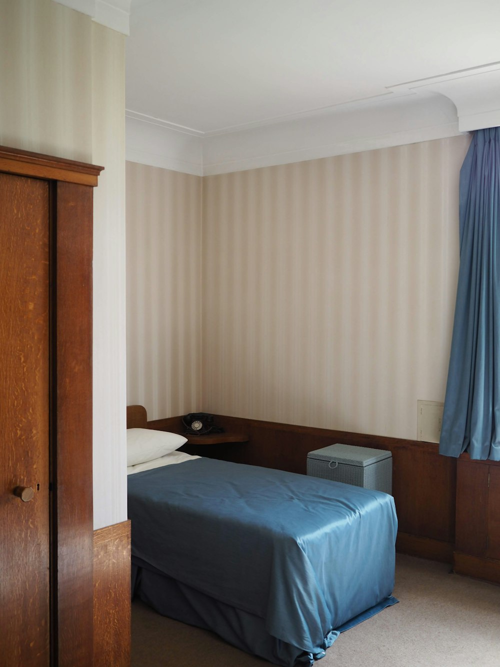 blue bed linen near brown wooden door