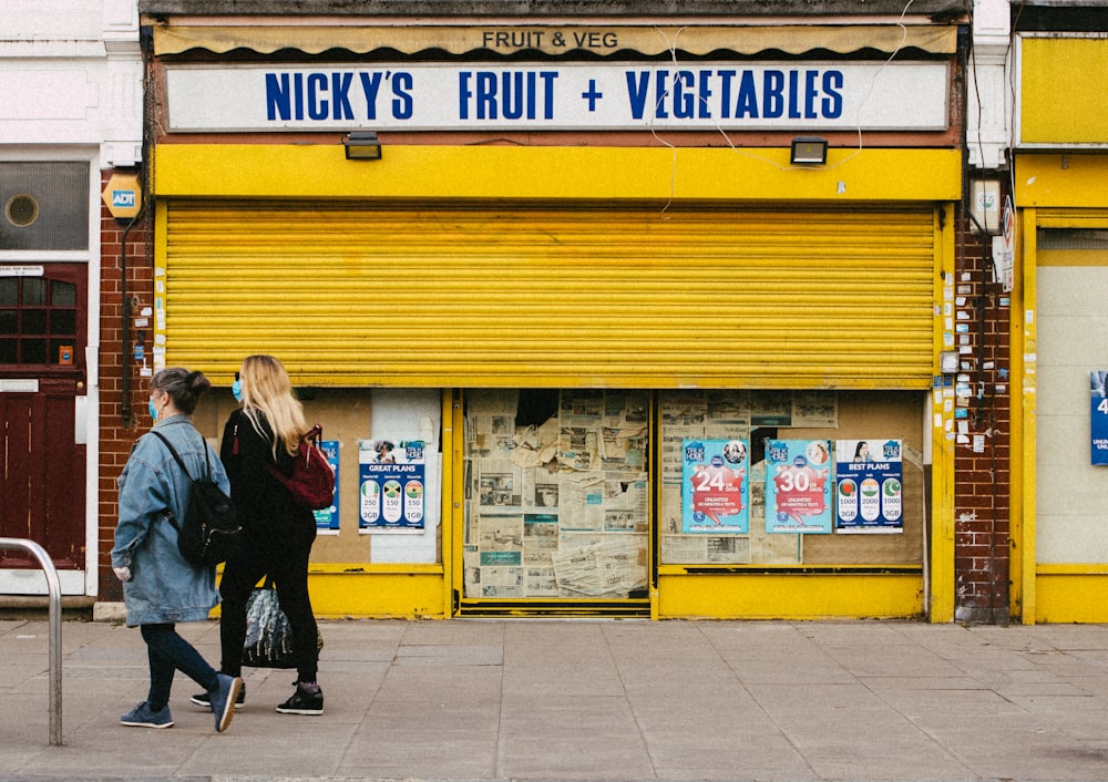 woman in black jacket walking on sidewalk during daytime