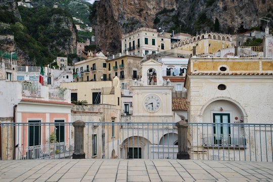 white and brown concrete building near mountain during daytime in Amalfi Coast Italy