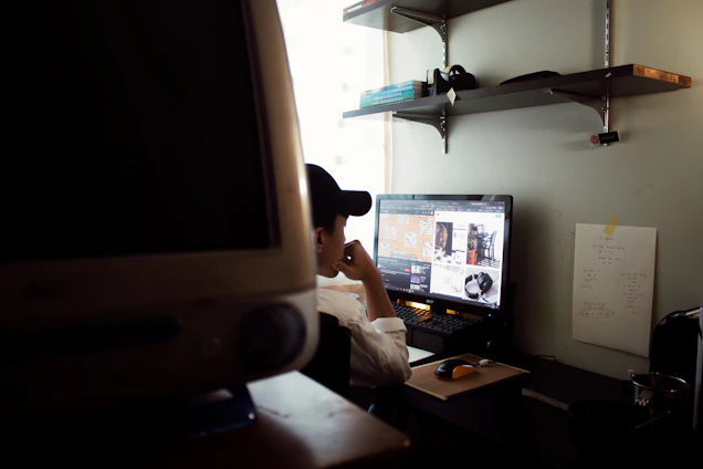 Dr. Kenneth Sessions thoughtfully working at his desk surrounded by technology and certification plaques.