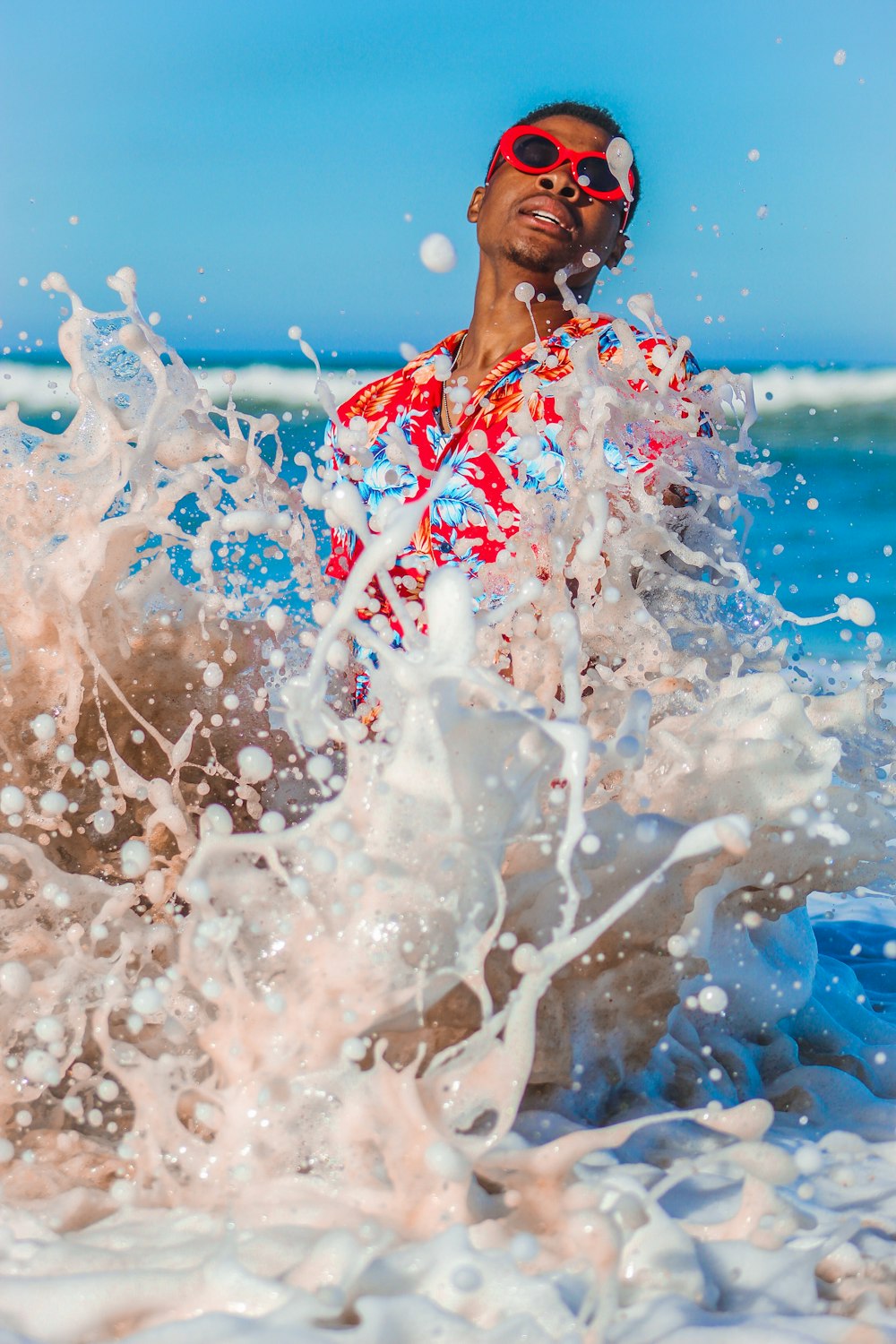 woman in blue and white floral shirt blowing bubbles