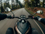 A dynamic shot of a rider cruising on a Honda bike through a forested highway