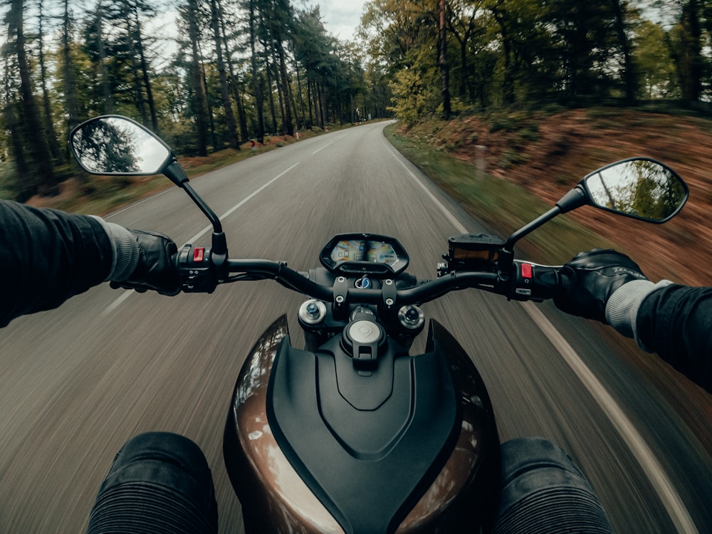 Melns un pelēks motocikls uz ceļa