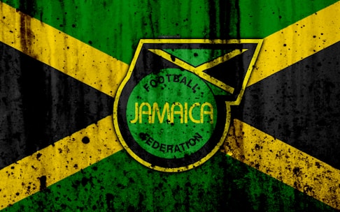 A grunge-style design features the Jamaican flag in the background, with a prominent emblem in the center displaying the words 'Football Jamaica Federation.' The flag consists of green, yellow, and black colors arranged in cross and triangular patterns.