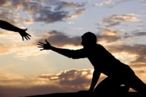 An inspiring sunset view symbolizing vision, with hands reaching toward the horizon.