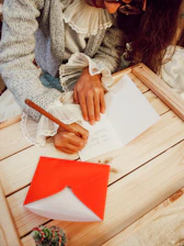 woman in gray sweater holding red paper