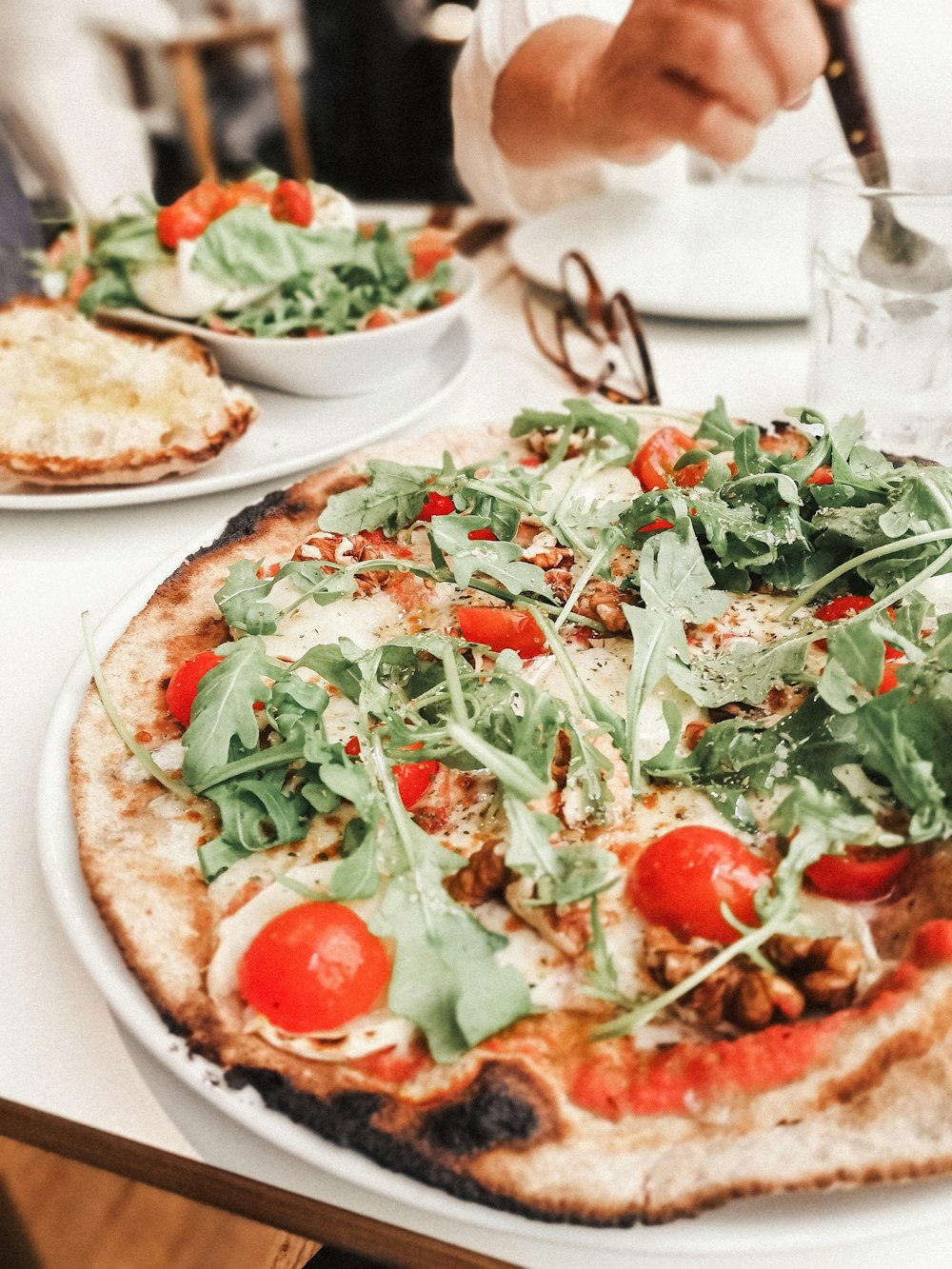 pizza with green leaves on white ceramic plate