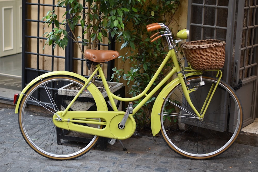 Bicicleta amarilla estacionada junto a una pared de ladrillos marrones