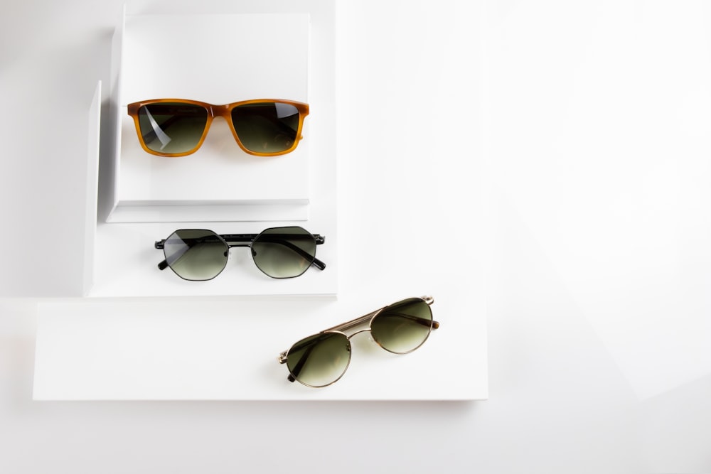 gafas de sol con montura negra sobre mesa blanca