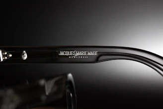 Close-up of premium sunglasses with intricate laser engraving on the temple and leather case, highlighting luxury craftsmanship