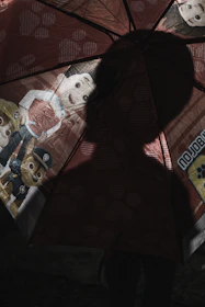 A golden umbrella shielding a group of people from a stormy, dark background.