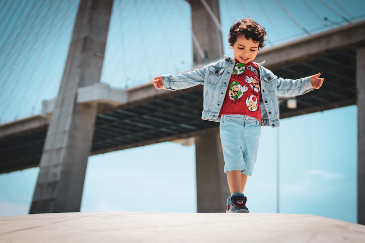 a little boy that is standing on a ledge