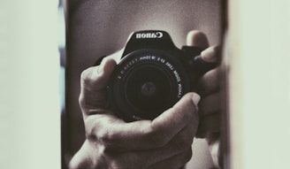 Close-up of hands gently holding a video camera, representing care and the preservation of memories.