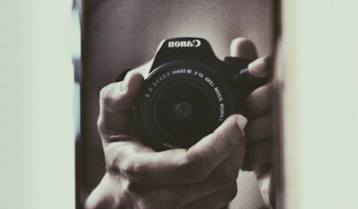 Close-up of hands gently holding a video camera, representing care and the preservation of memories.