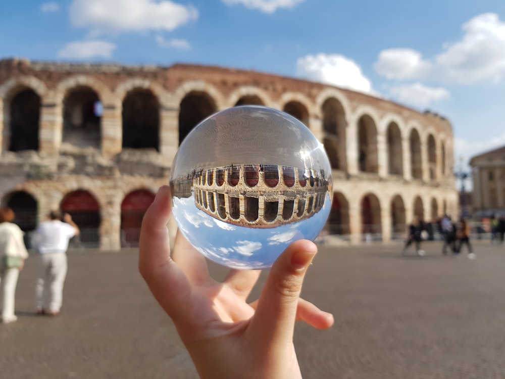 person holding clear glass ball