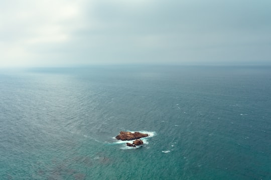 brown rock on blue sea under gray sky in Cabo da Roca Portugal