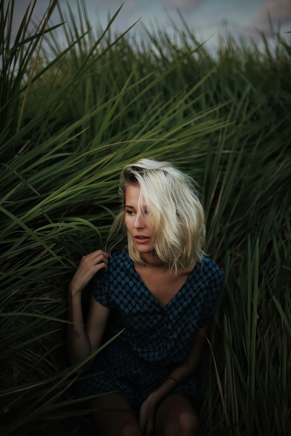 woman in blue and black checkered shirt standing on green grass field during daytime