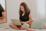 woman in black tank top using macbook