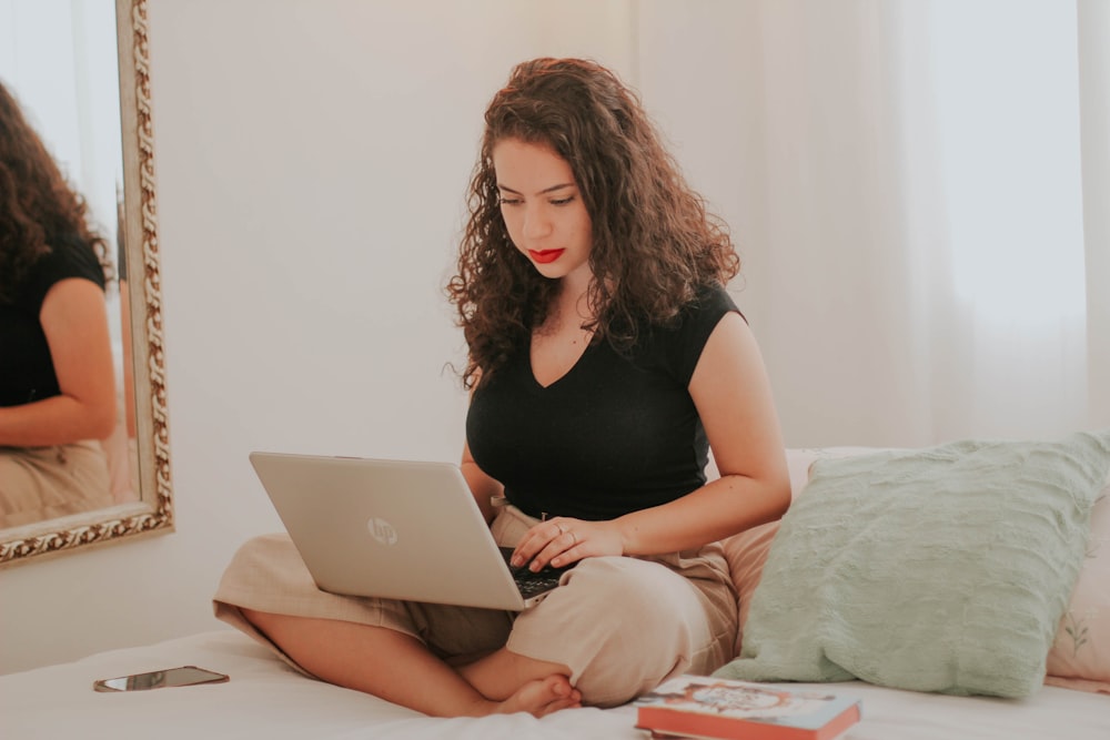 woman in black tank top using macbook