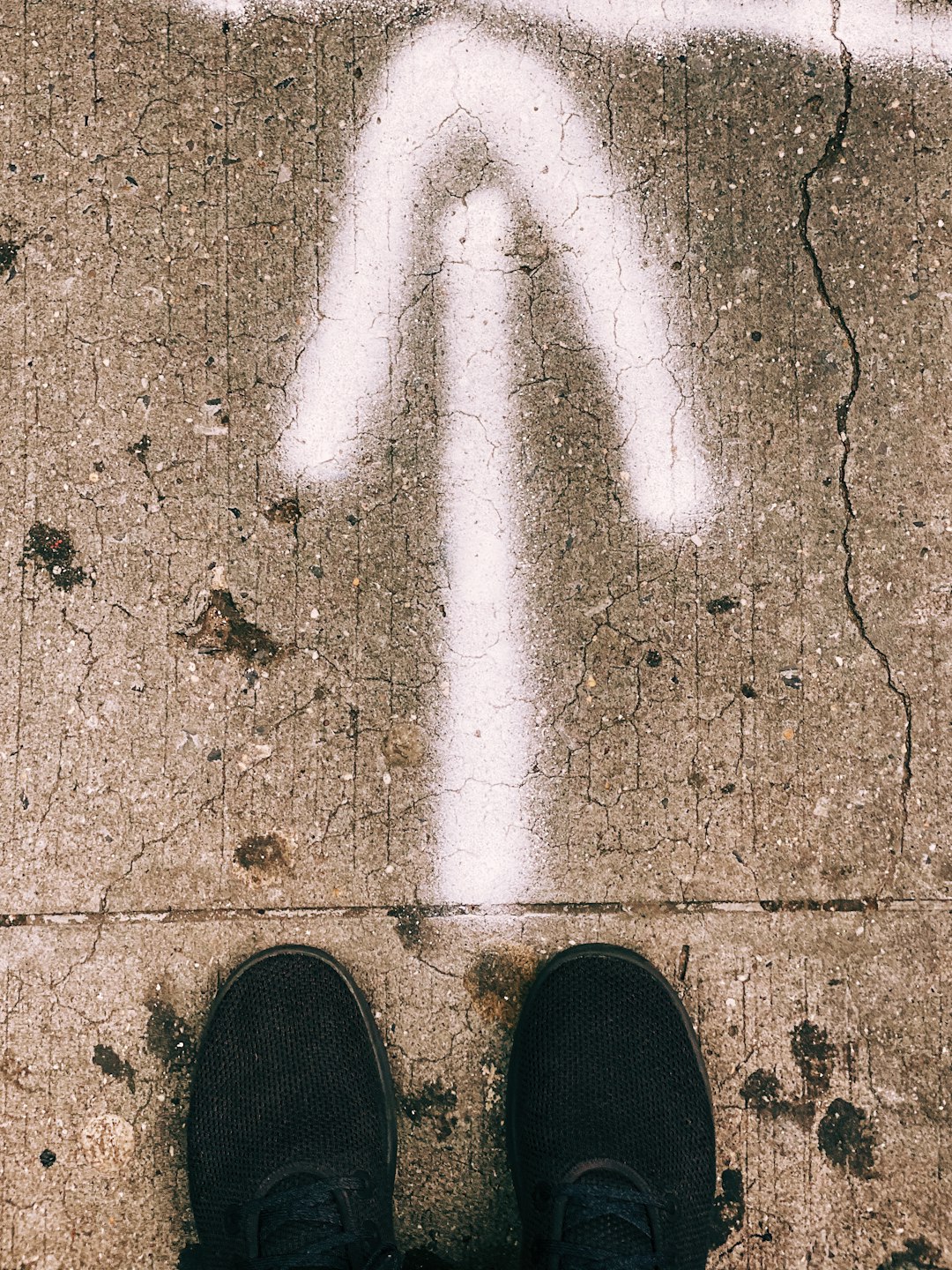 person wearing black shoes standing on brown concrete floor