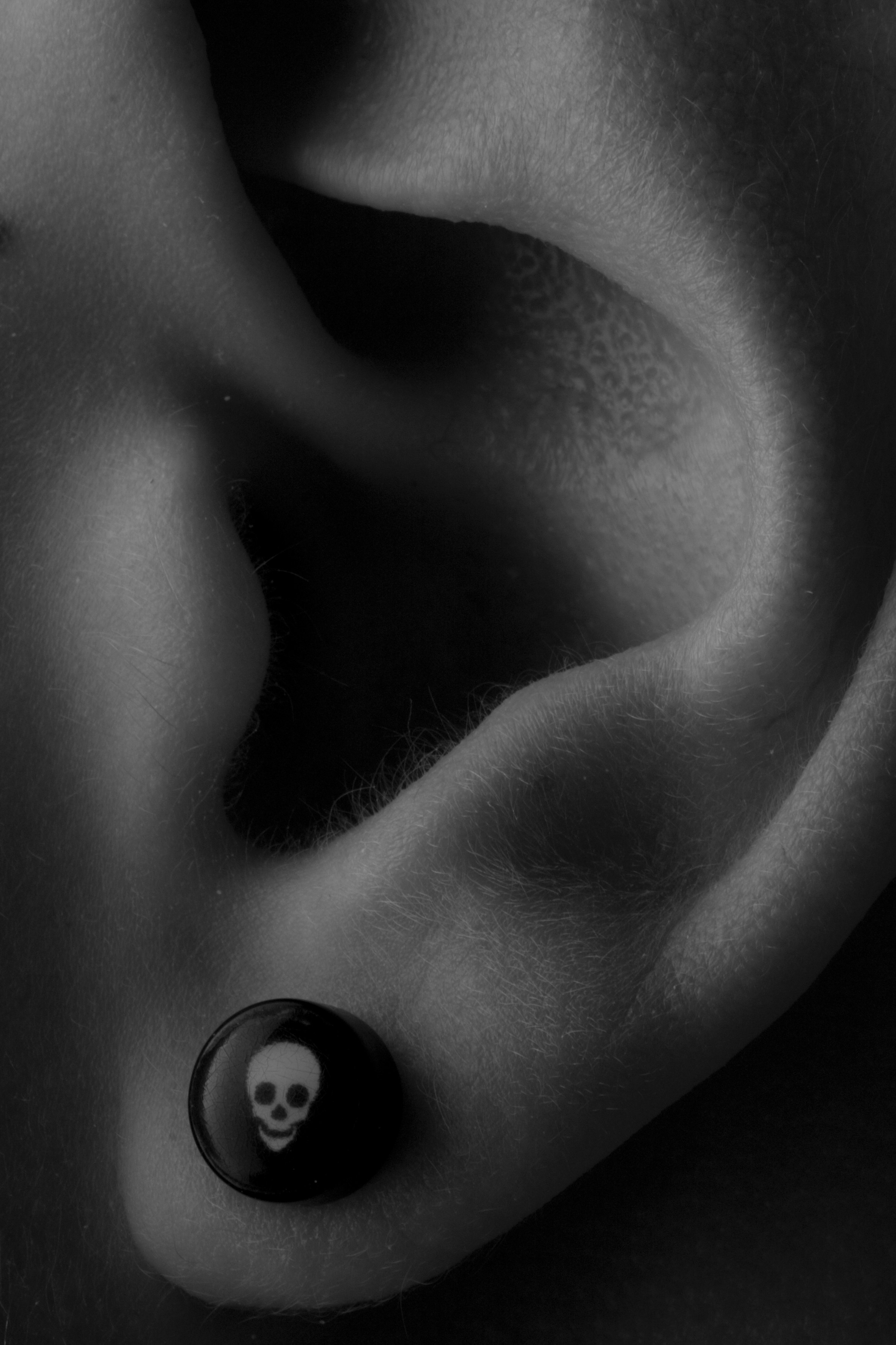 Detail shot of ear with skull earring