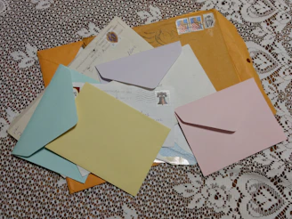 An assortment of colorful envelopes stacked neatly on a wooden table.