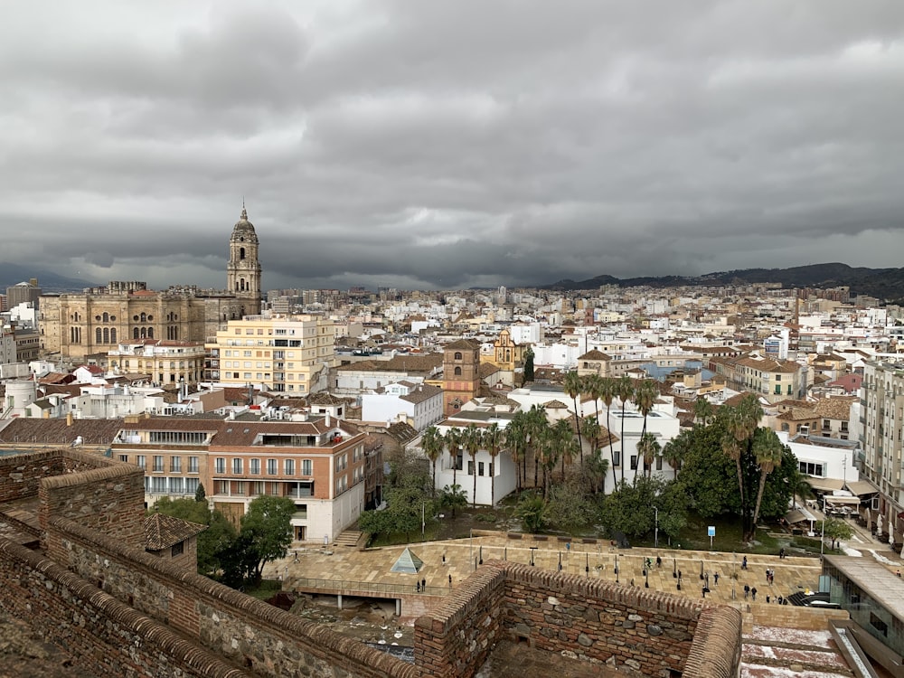 city with high rise buildings under white cloudy sky during daytime