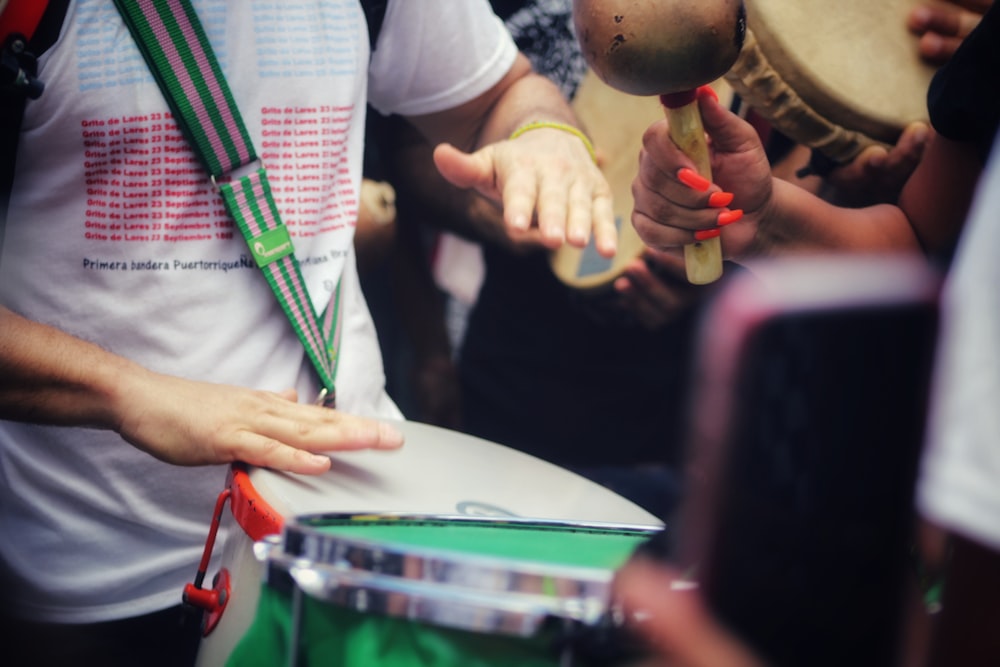 person in white long sleeve shirt holding drum stick