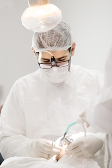 Close-up of a dermatologist examining a patient's scalp under a magnifying lamp in a modern clinic.