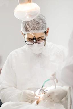 Technician repairing a medical device with precision tools in a clinical setting