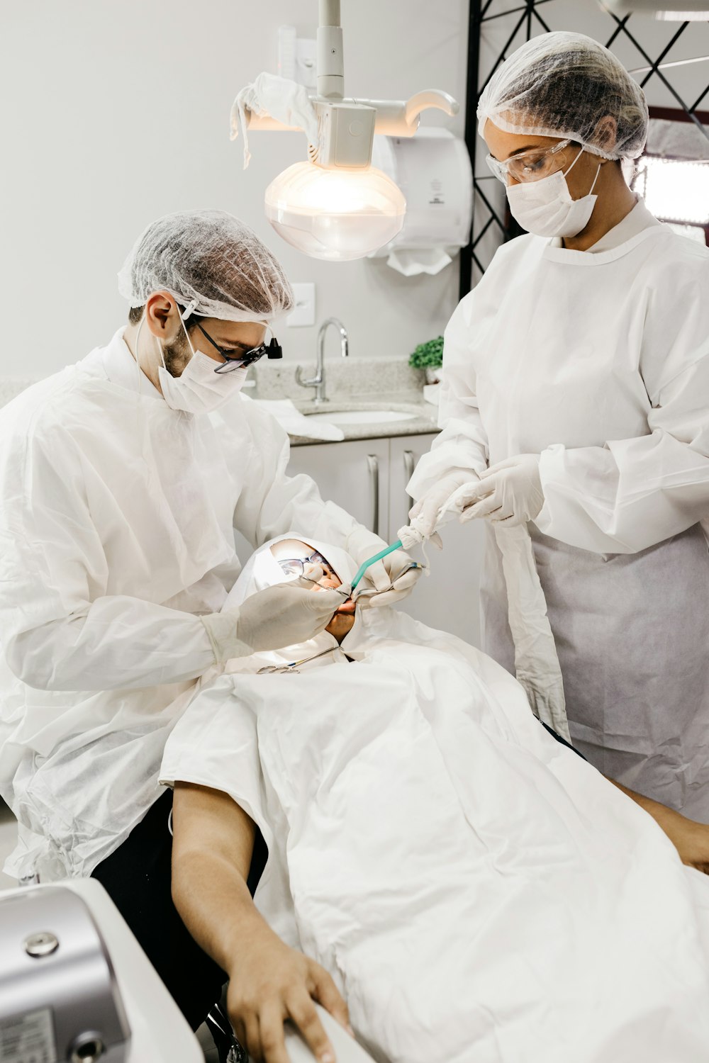 woman in white scrub suit holding white and green hose