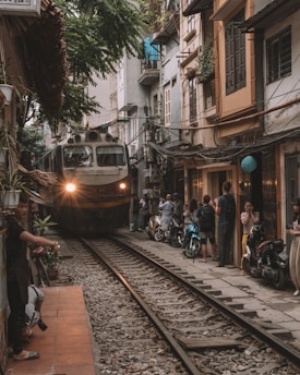 people walking on sidewalk near train during daytime