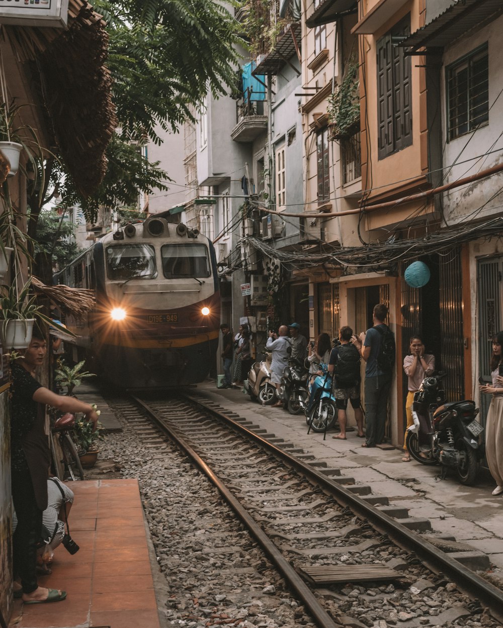 people walking on sidewalk near train during daytime