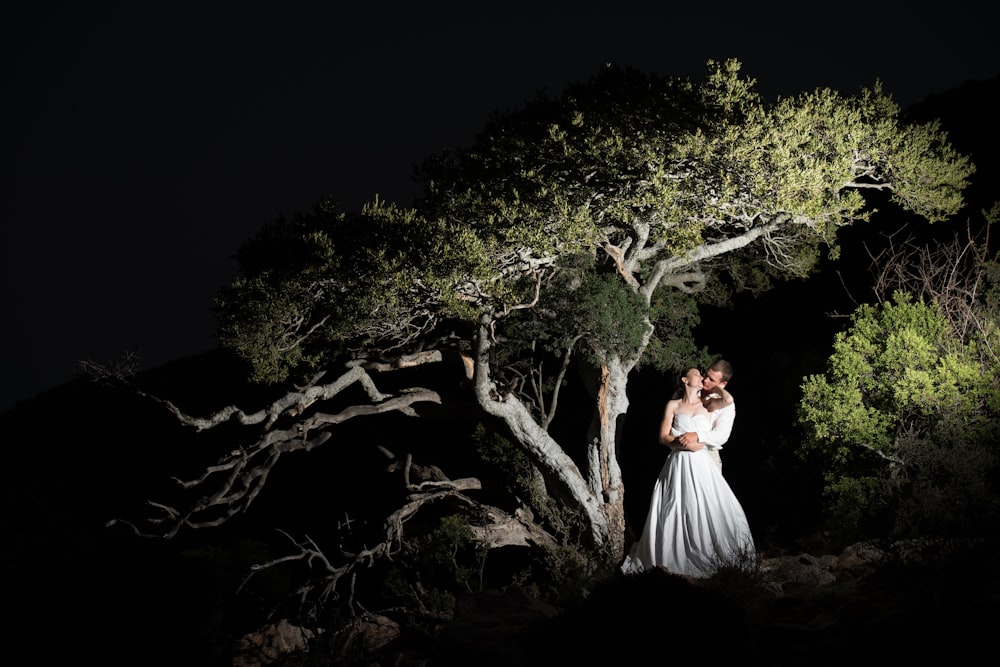 woman in white dress standing on brown tree branch