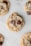 Several chocolate chip cookies are laid out on a white surface, showcasing their golden-brown color and rich chocolate pieces.