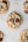 Several chocolate chip cookies are laid out on a white surface, showcasing their golden-brown color and rich chocolate pieces.