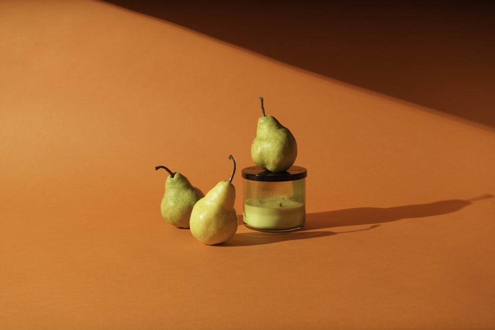 yellow pear fruit beside clear glass jar