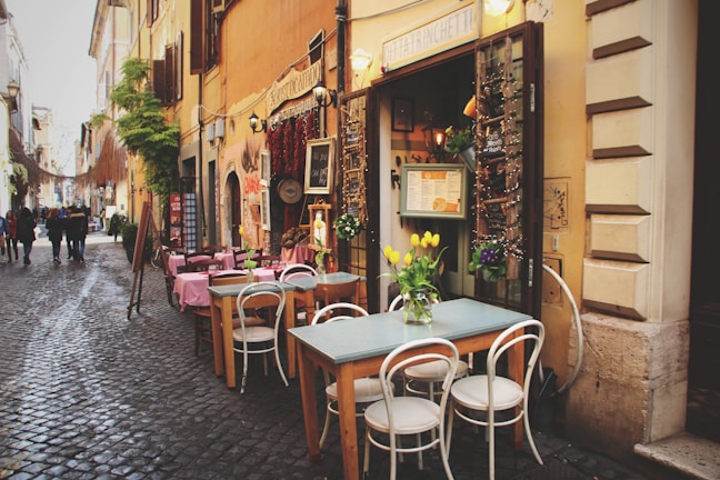 A charming cobblestone village street lined with quaint cafes and flowers.