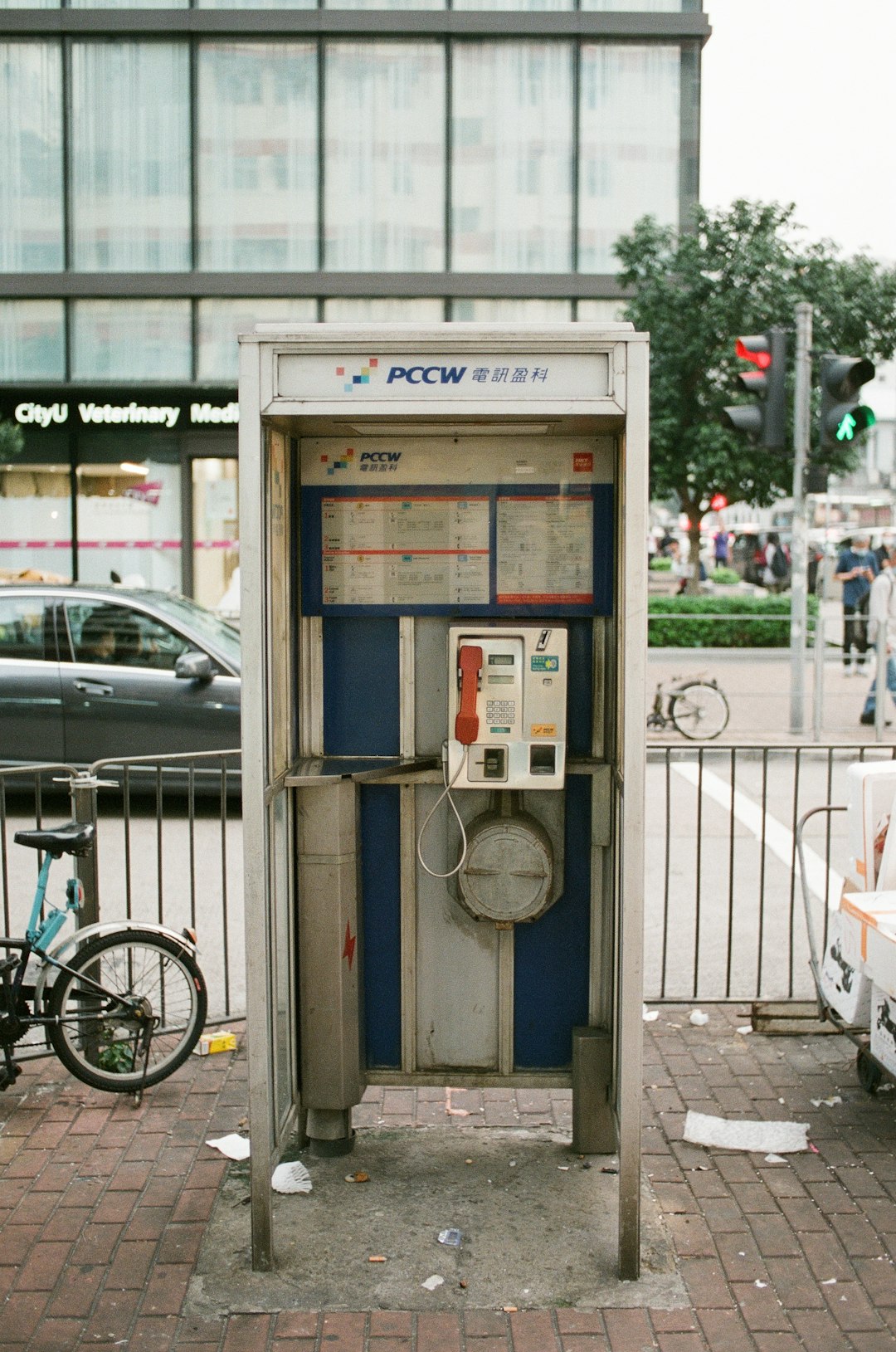 gray telephone booth near gray metal fence during daytime