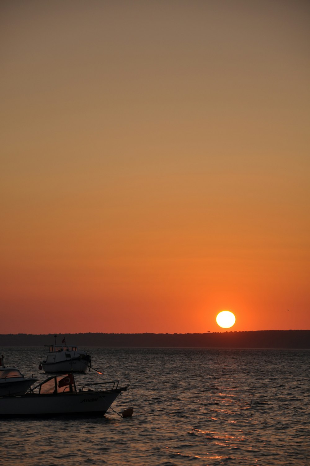 silhouette of boat on sea during sunset