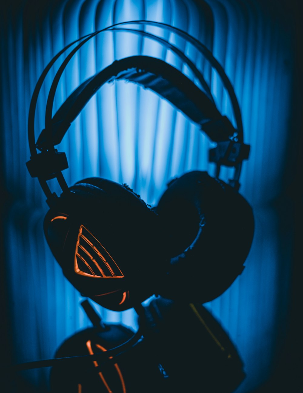 black and gray headphones on black and blue background