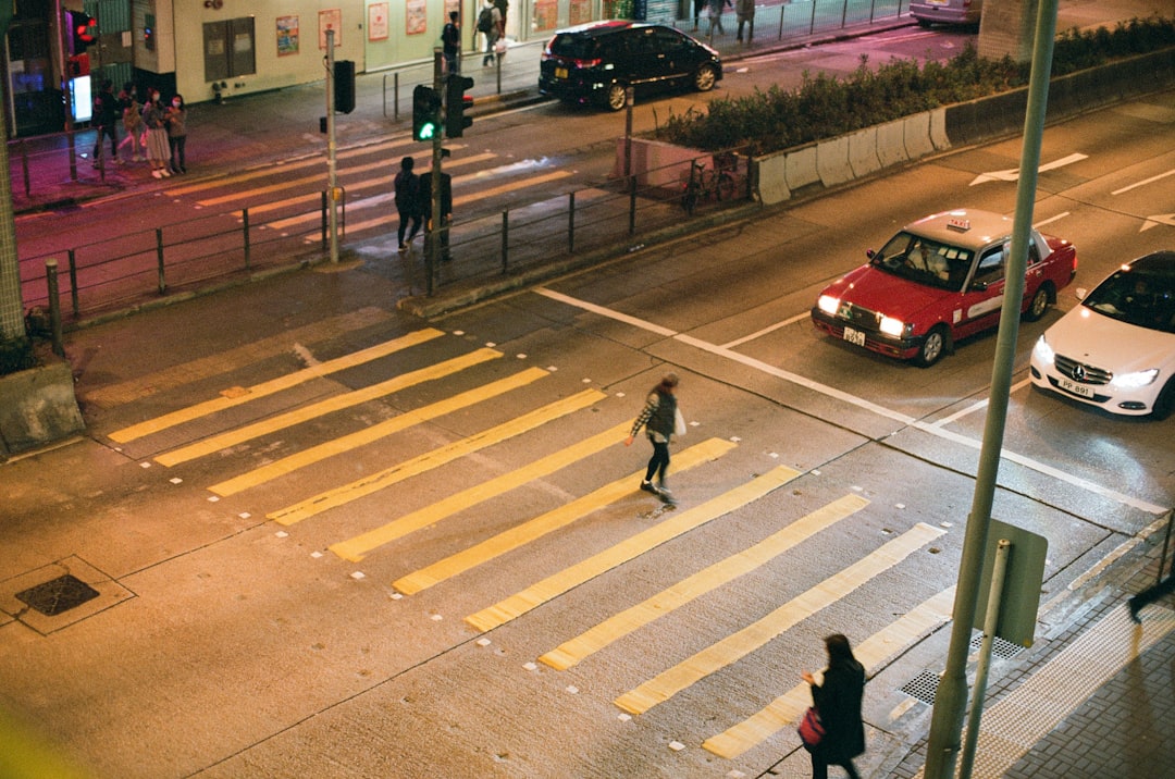 man in black jacket walking on pedestrian lane during daytime