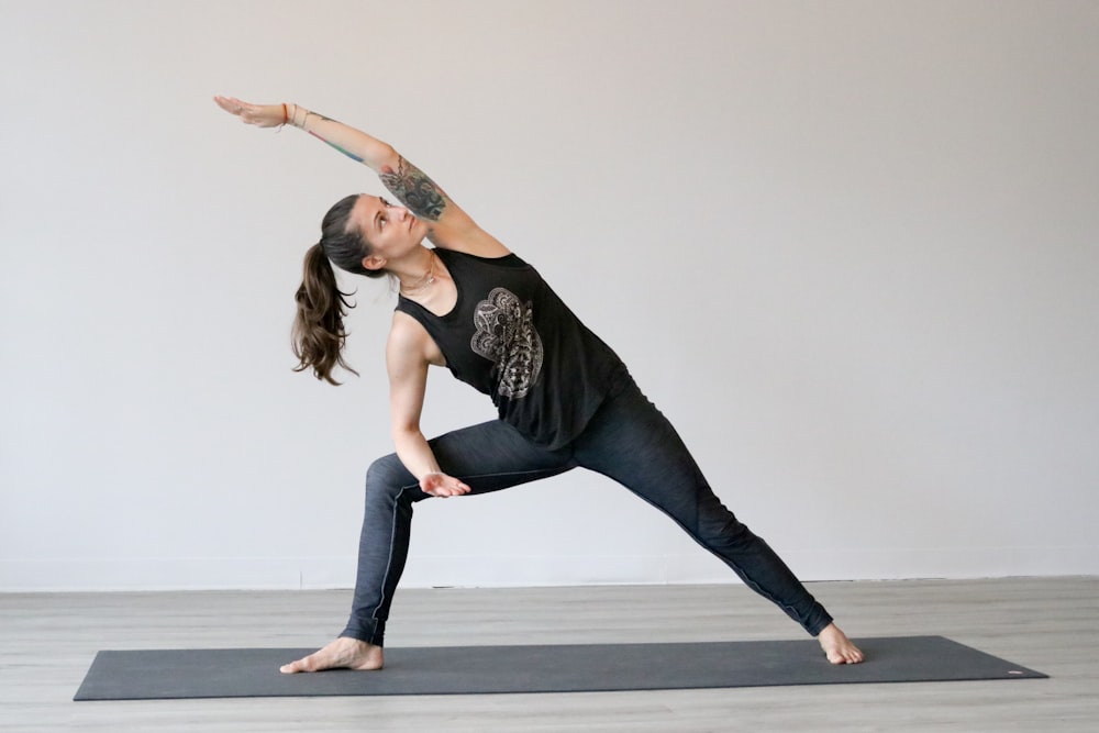 woman in black tank top and blue denim jeans jumping