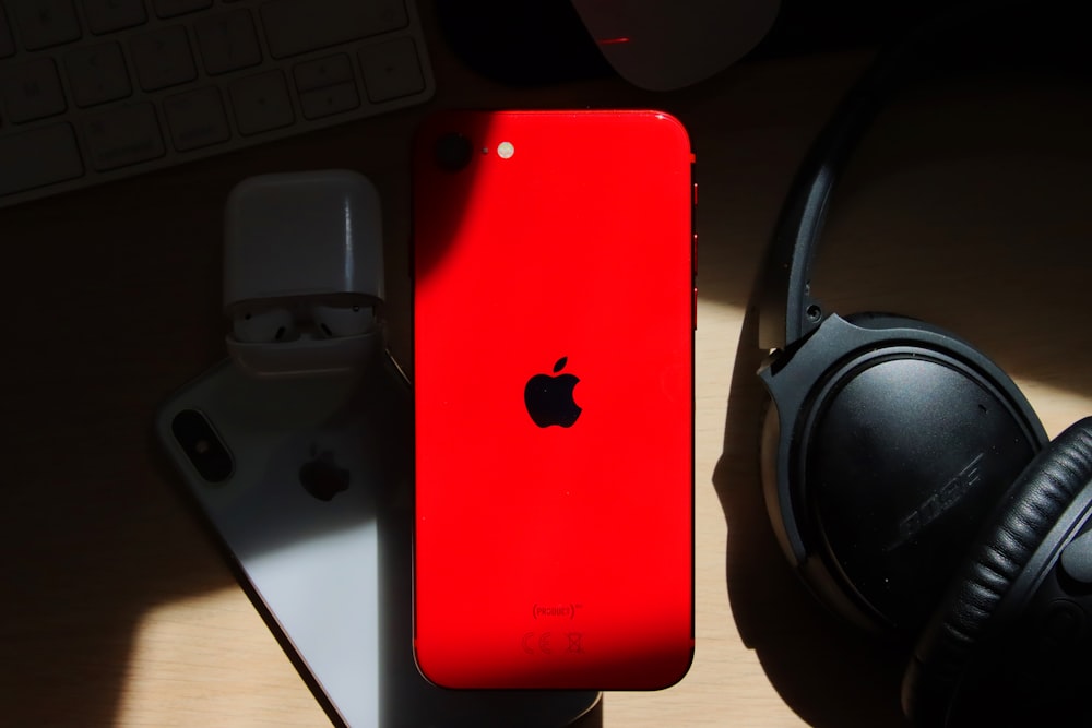red iphone 7 on black and gray headphones